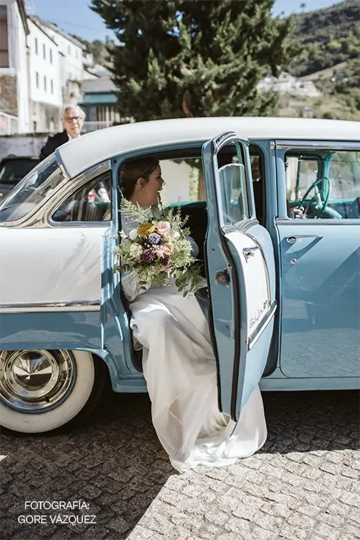 Novia con un ramo de flores original saliendo del coche a las puertas de la iglesia