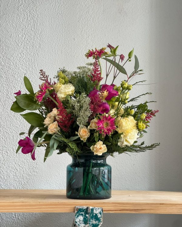 Ramo de flores en jarrón de cristal verde