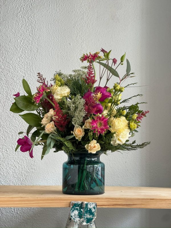 Ramo de flores en jarrón de cristal verde